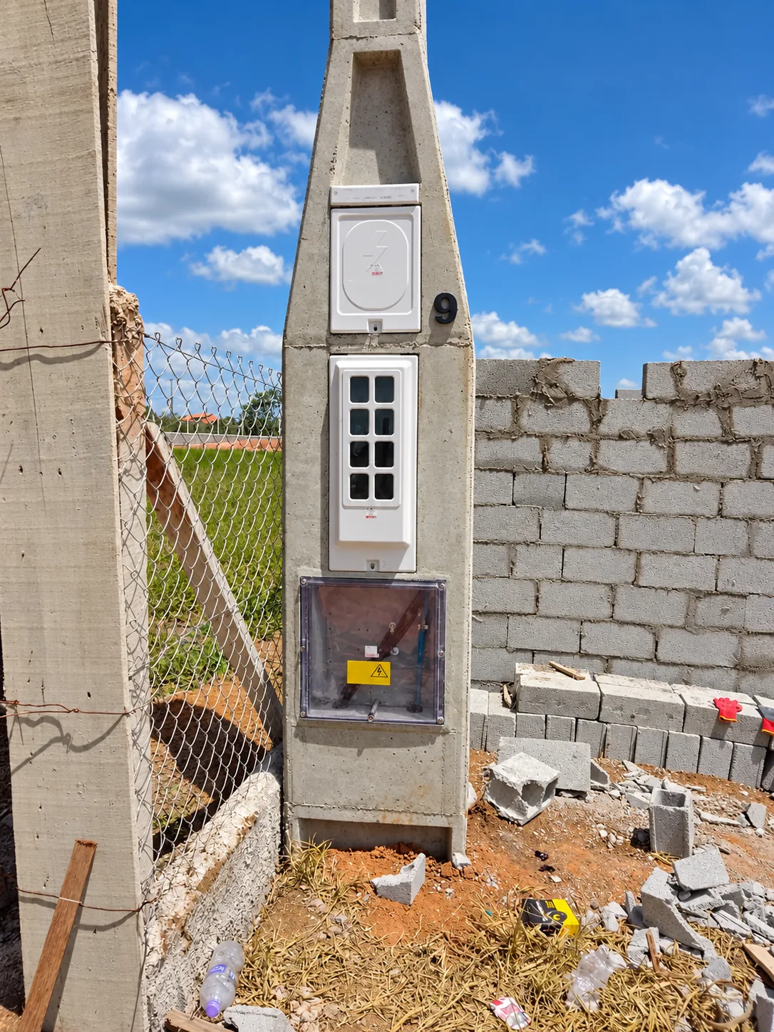 Poste do grupo C4 a C6 junto a um muro em construção